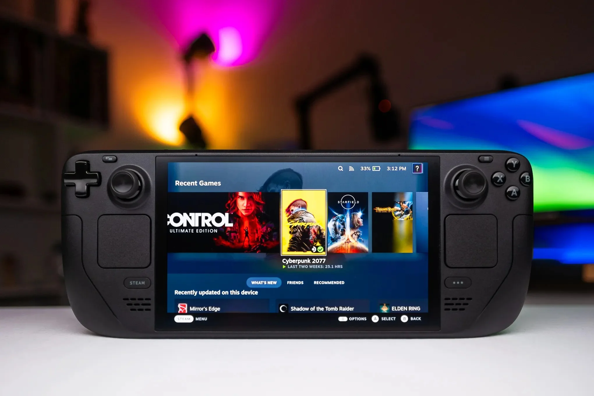 An OLED Steam Deck showing the Steam interface with games including Control