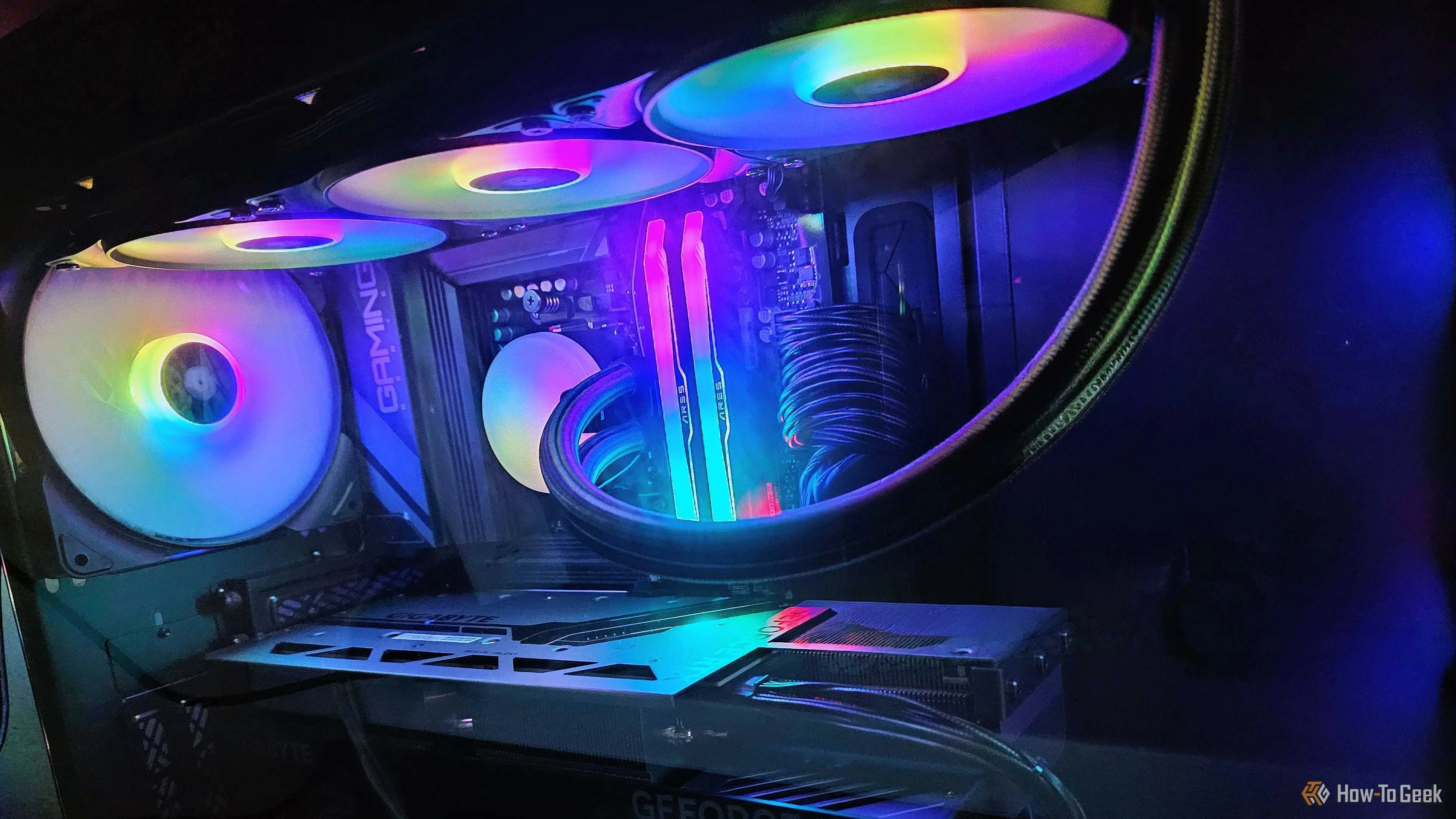 The inside of a gaming PC, showing the AIO cooler, the GPU, and a case fan.