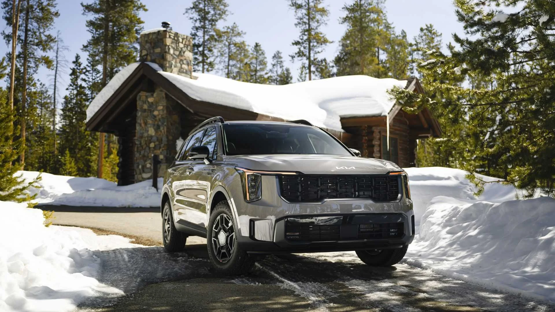 Static frotn 3/4 shot of a 2025 Kia Sorento parked on the driveway of a home after it's snowed.
