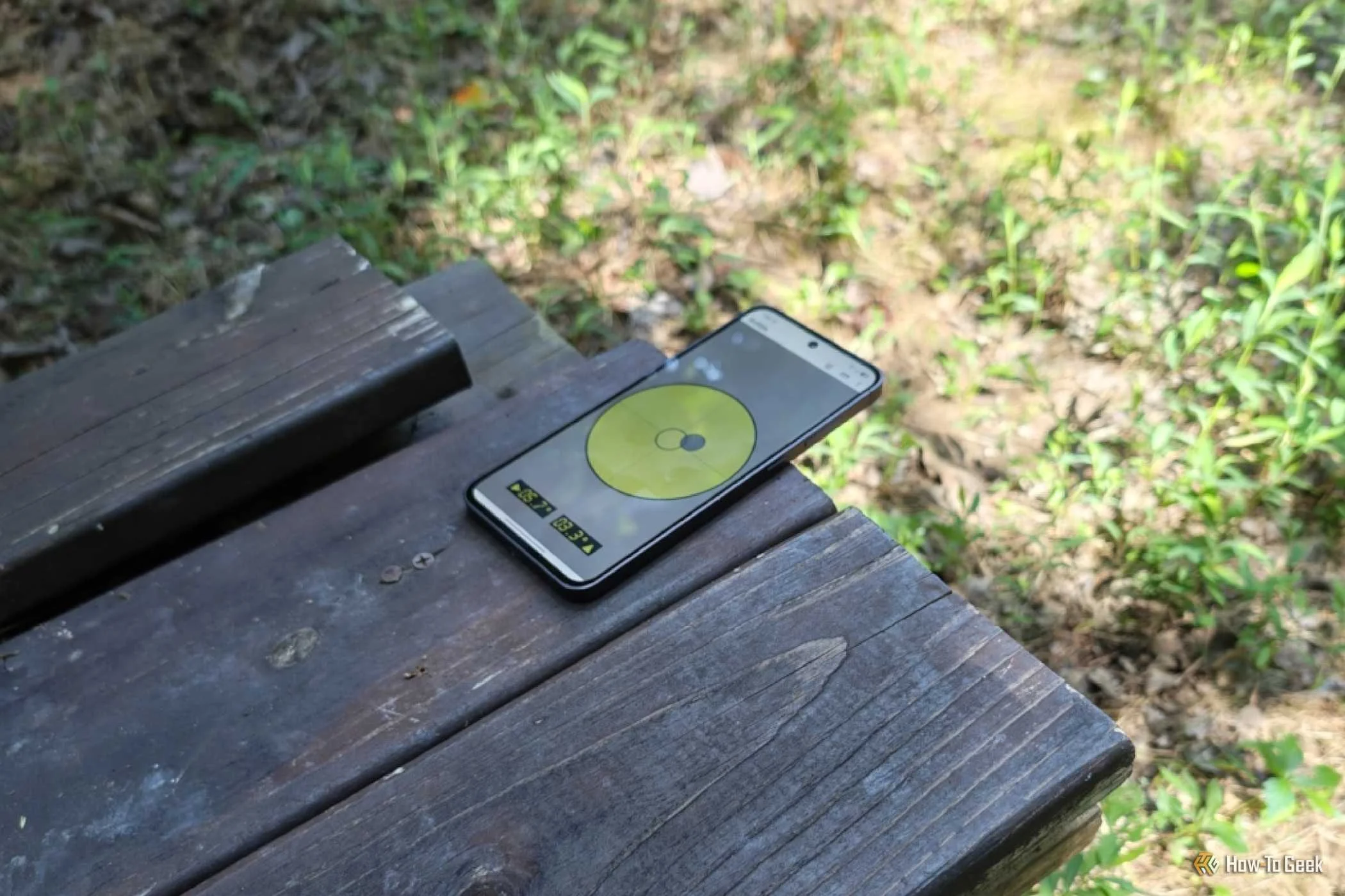A level app displayed on a Samsung Galaxy phone to gauge the level of a wooden bench.