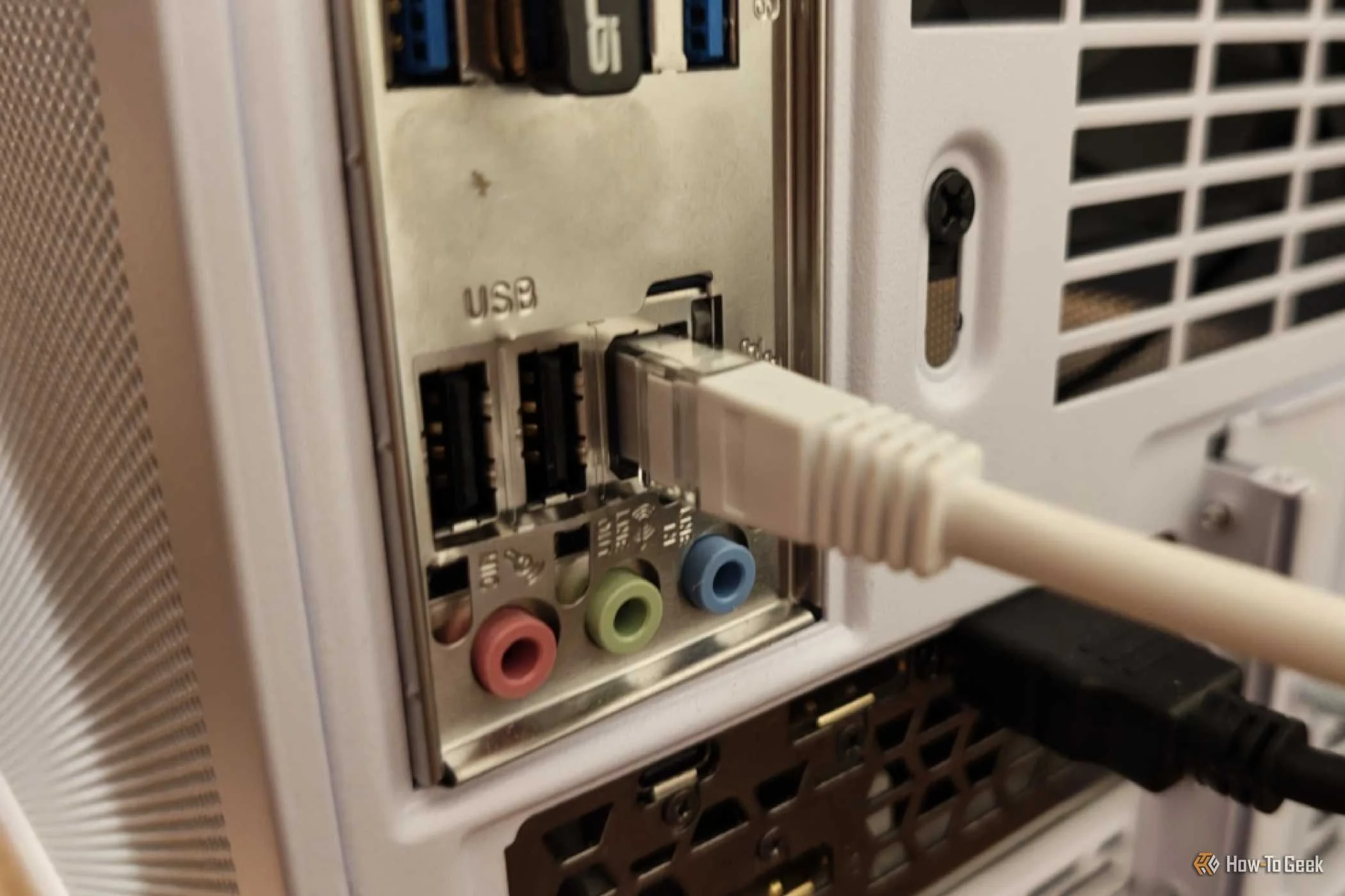 An Ethernet cable plugged into the back of a desktop PC.