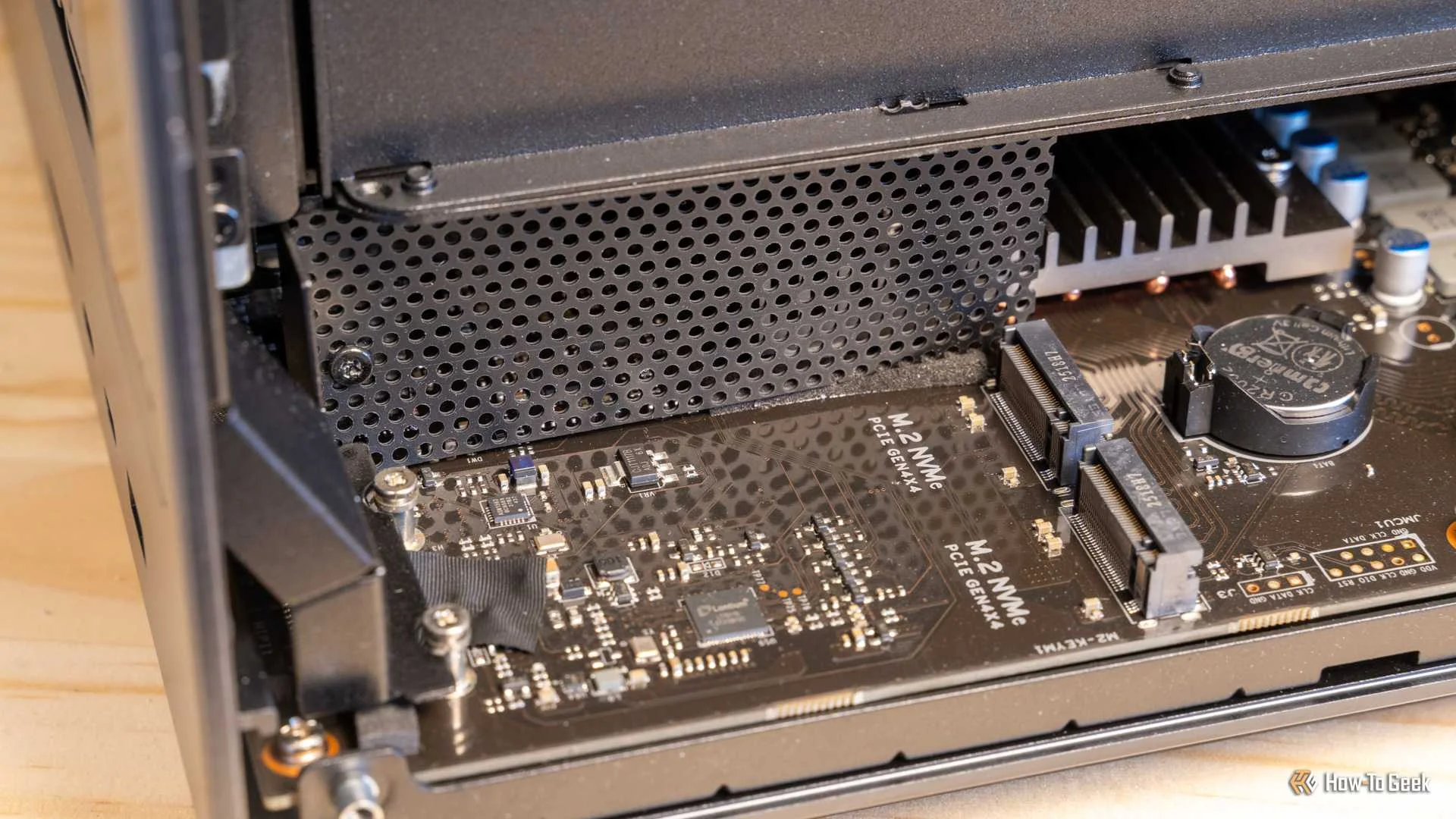 The Ugreen iDX6011 Pro NAS interior with the bottom panel removed showing the full motherboard and M.2 slots.