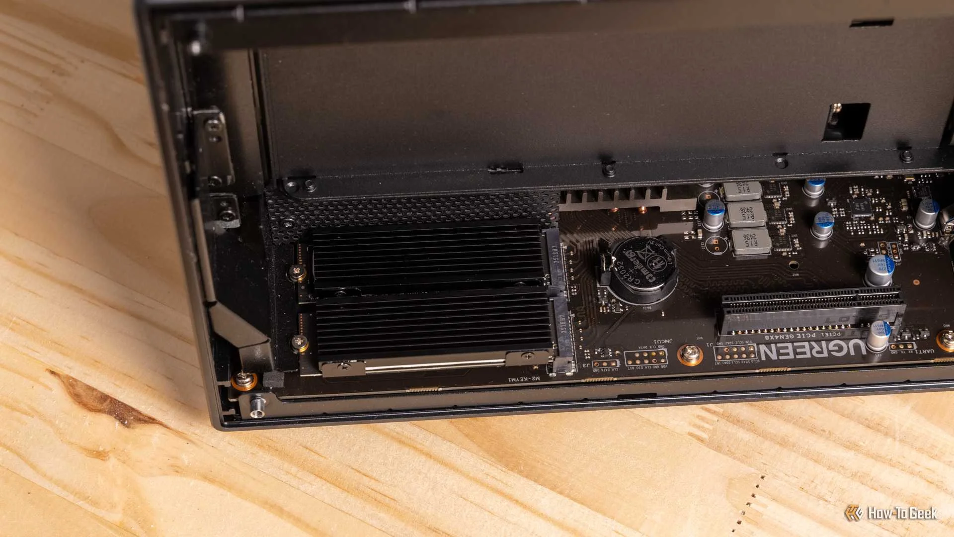 A wide view of the Ugreen iDX6011 Pro NAS motherboard with the M.2 heatsink installed and PCIe slot visible.