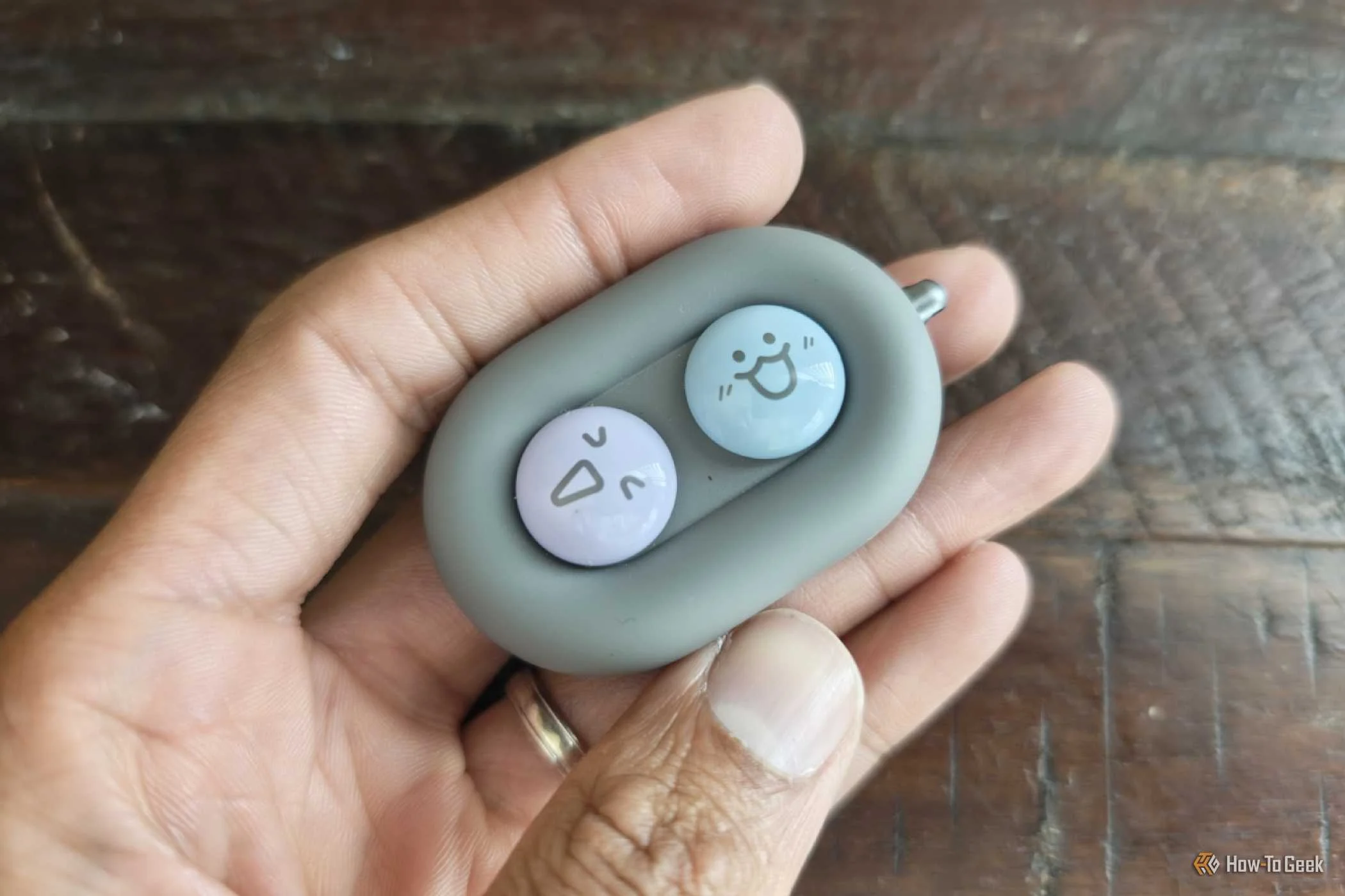 Hand holding a DuRoBo Moodi Bluetooth page turner with alternate button caps. 
