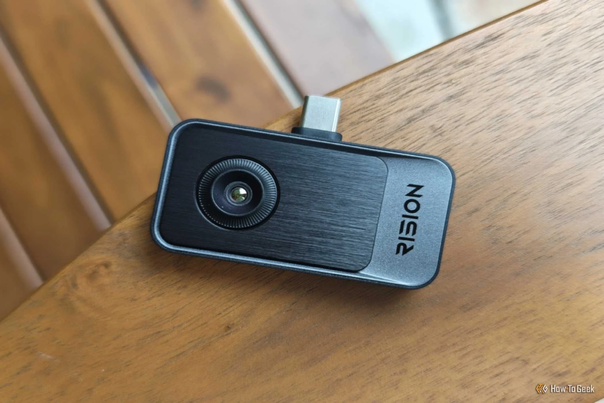 Rision Magic Pro thermal camera resting on a wooden arm chair.