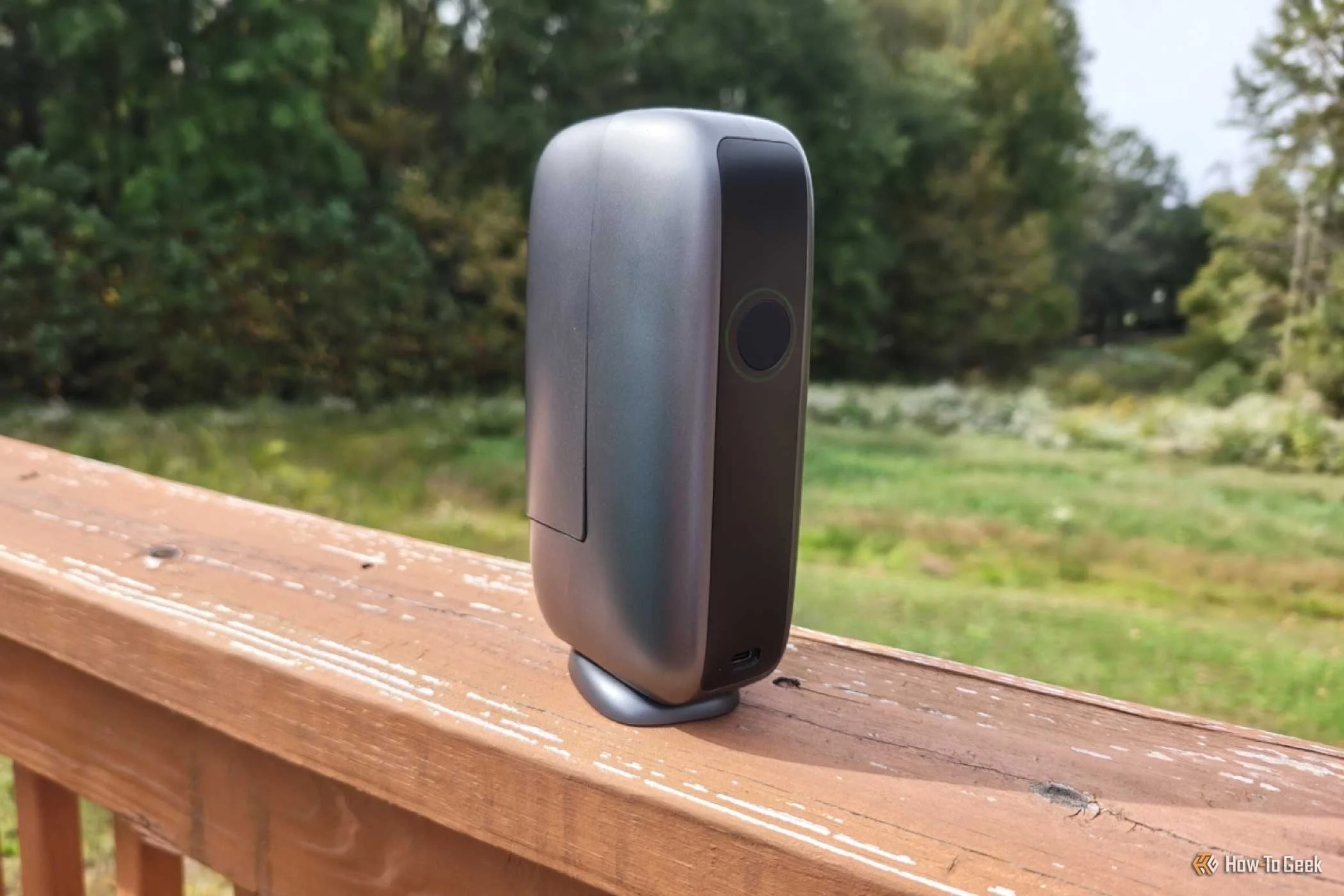 DWARF mini smart telescope on a wooden porch railing.