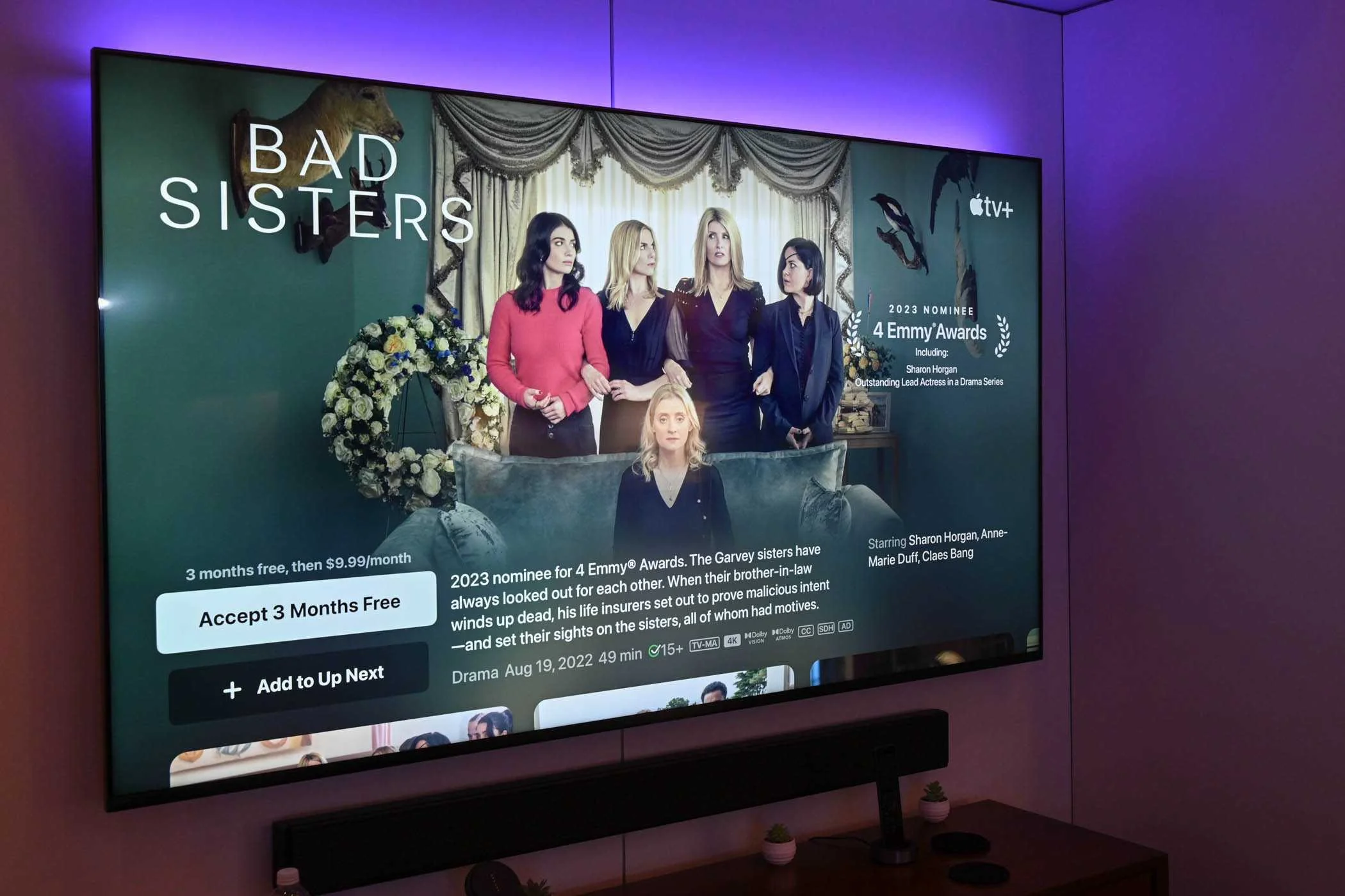 Colored lights behind a Smart TV with Apple TV open.