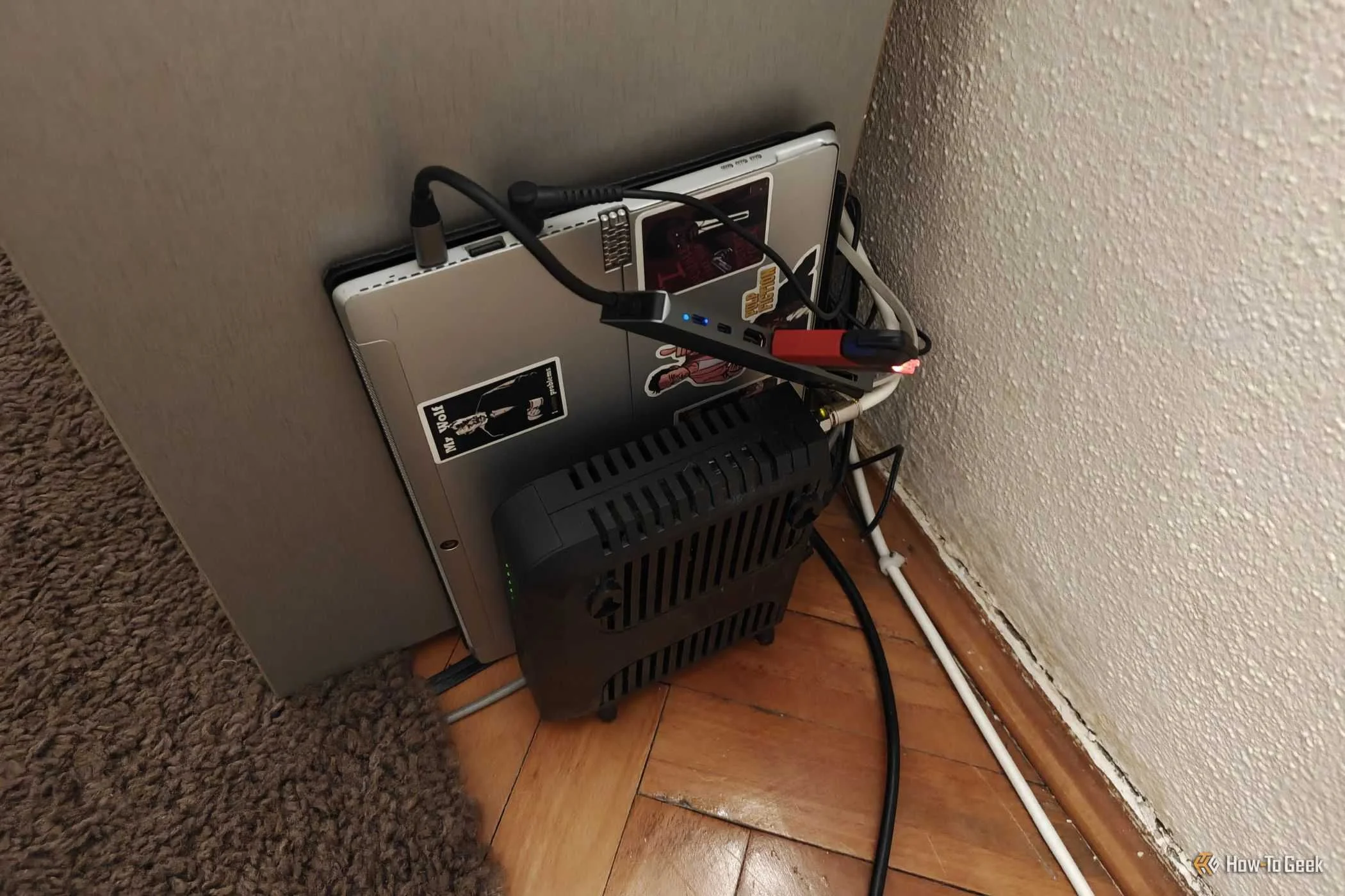 A laptop that serves as a home server next to a router.