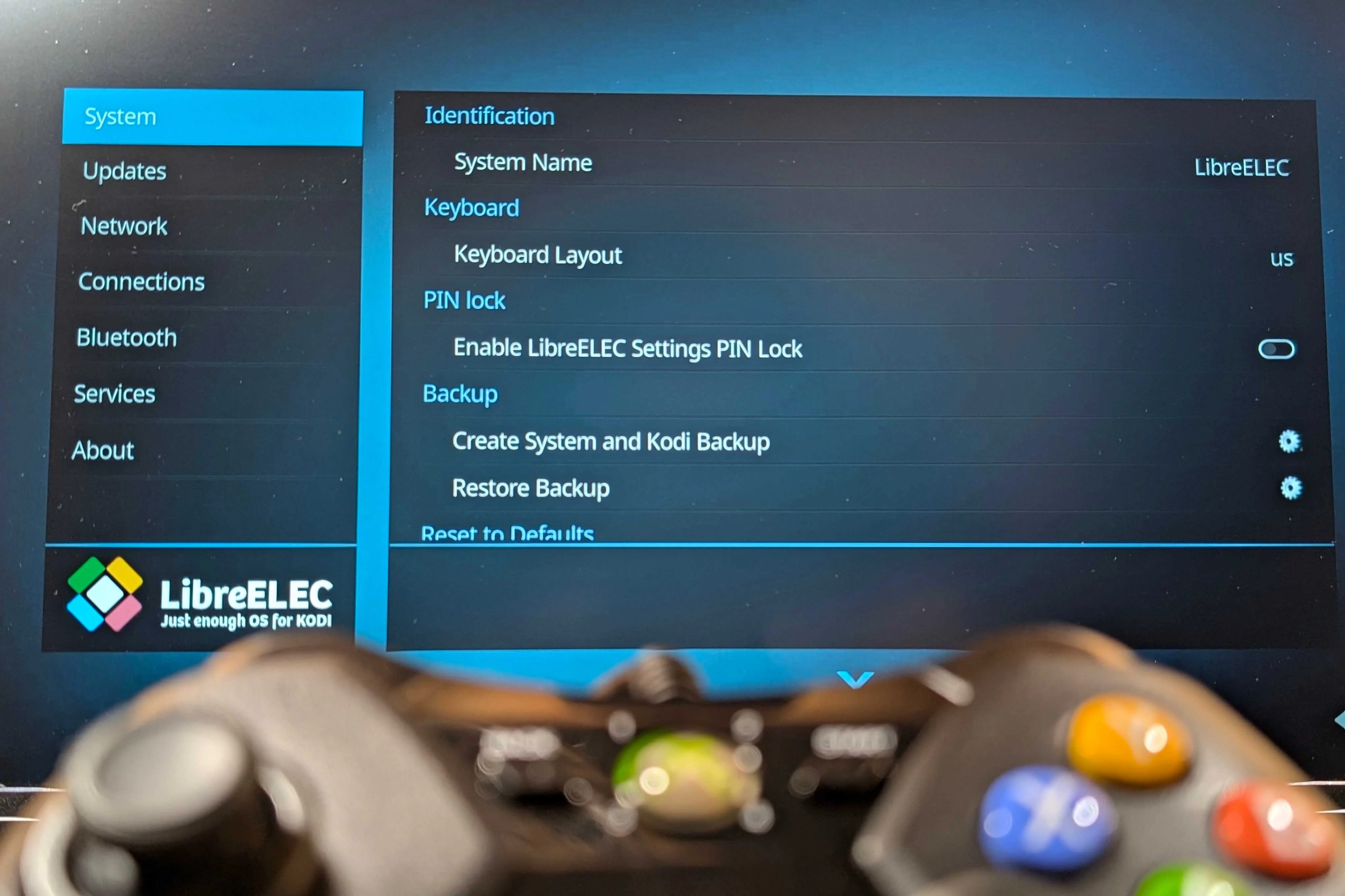 An XBOX controller in the foreground with LibreELEC in the background.
