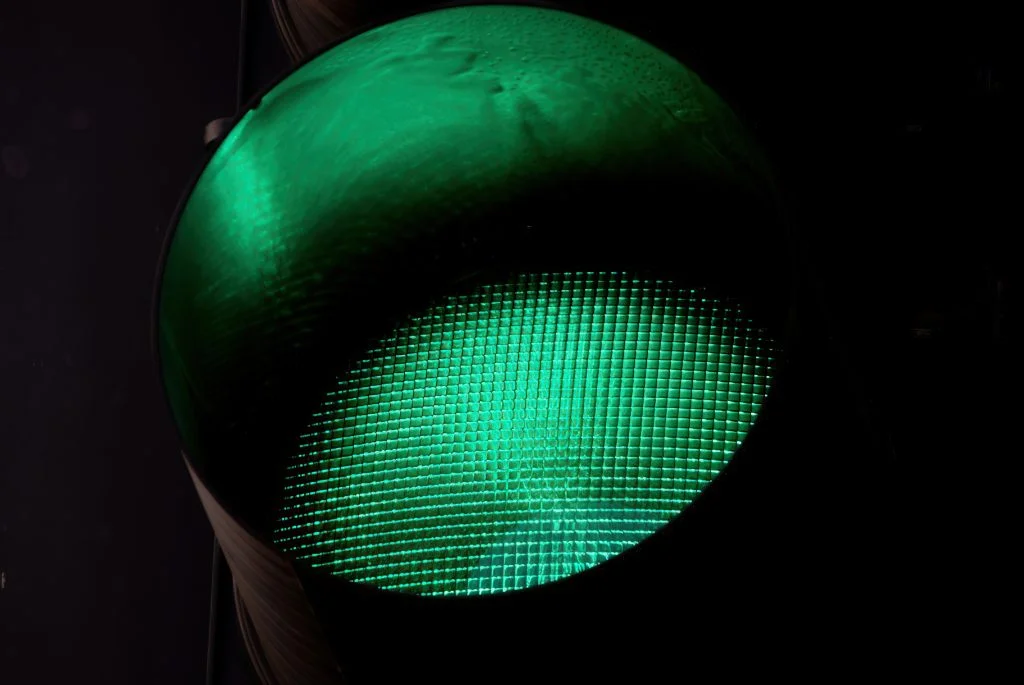 A glowing green circular surface with a fine square grid pattern emerges from a dark background.
